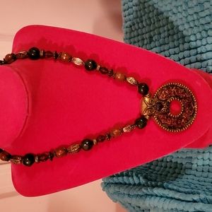 Jewel-toned beaded statement necklace with purple medallion pendant accent